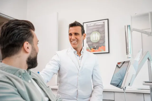 Dr. Tran discussing root canal treatment costs with a patient at Peninsula Dentistry in Huntington Beach